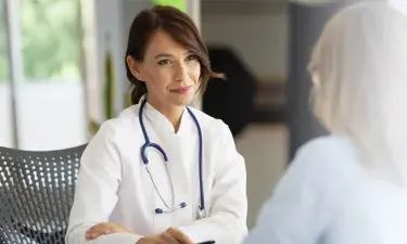 WHNP 在蒙大拿 smiling 和 discussing treatment options with patient