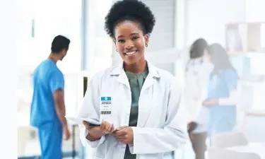 蒙大拿 DNP nurse executive smiling with patient charts in hospital